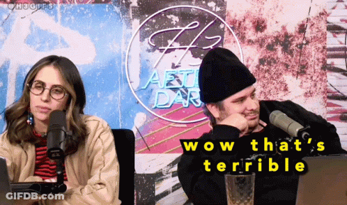 A Man And A Woman Are Sitting In Front Of Microphones And A Sign That Says Wow That 'S Terrible GIF