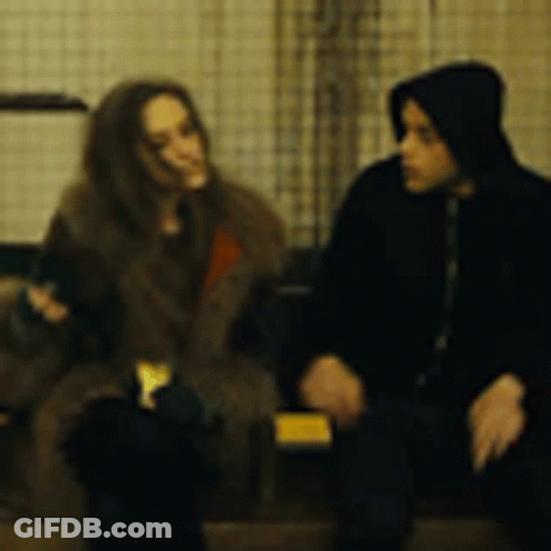A Man And A Woman Are Sitting Next To Each Other And Talking . GIF