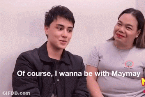 A Man And A Woman Are Sitting Next To Each Other And Talking . The Man Is Talking About Being With Maymay . GIF