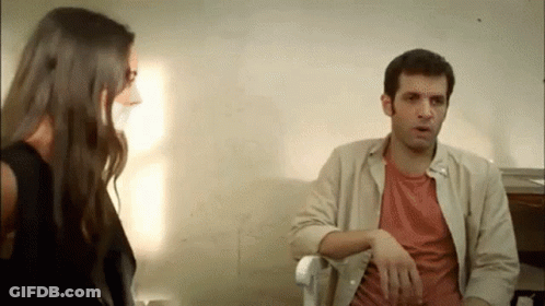 A Man And A Woman Are Sitting Next To Each Other And Talking To Each Other . GIF