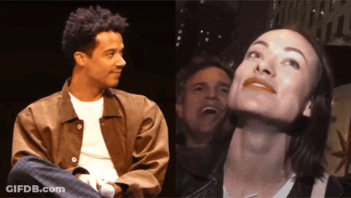 A Man And A Woman Are Sitting Next To Each Other And The Woman Is Smiling GIF