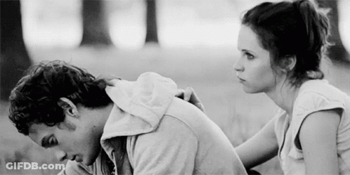 A Man And A Woman Are Sitting Next To Each Other In A Black And White Photo . GIF