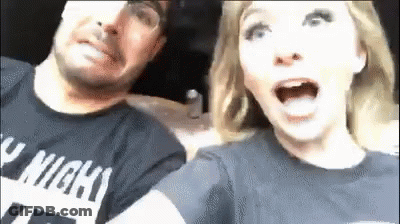 A Man And A Woman Are Sitting Next To Each Other In A Car And The Woman Is Screaming . GIF
