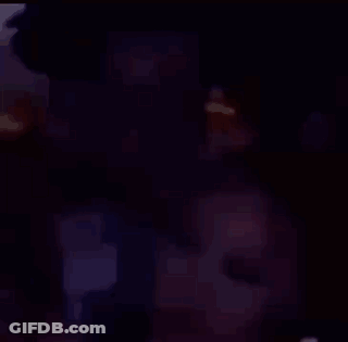 A Man And A Woman Are Sitting Next To Each Other In A Room . GIF