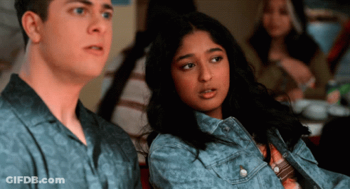 A Man And A Woman Are Sitting Next To Each Other In A Room GIF