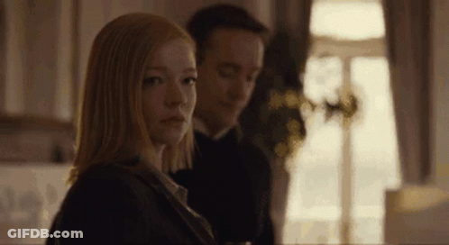 A Man And A Woman Are Sitting Next To Each Other In Front Of A Window . GIF