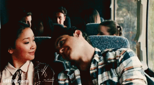A Man And A Woman Are Sitting Next To Each Other On A Bus And The Man Is Sleeping . GIF