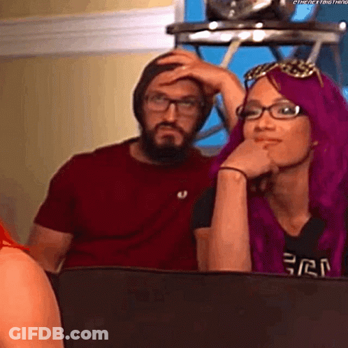 A Man And A Woman Are Sitting Next To Each Other On A Couch . GIF