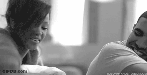 A Man And A Woman Are Sitting Next To Each Other On A Couch And Smiling . GIF