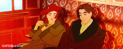 A Man And A Woman Are Sitting Next To Each Other On A Couch GIF