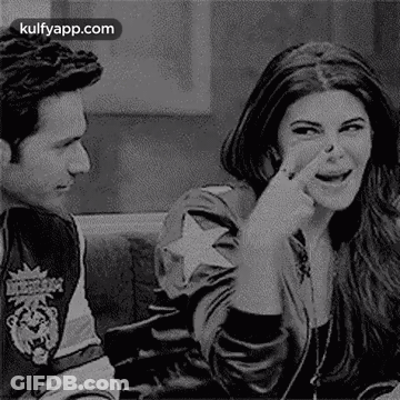 A Man And A Woman Are Sitting Next To Each Other On A Couch . The Woman Is Picking Her Nose . GIF