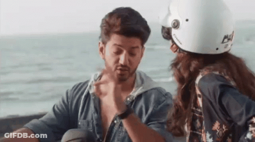 A Man And A Woman Are Sitting Next To Each Other On A Motorcycle . GIF