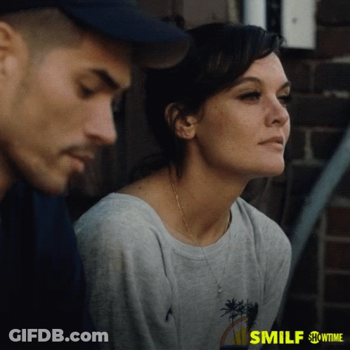 A Man And A Woman Are Sitting Next To Each Other On A Showtime Ad For Smilf GIF