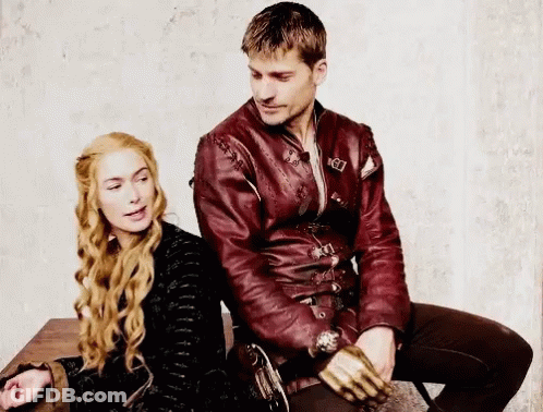 A Man And A Woman Are Sitting Next To Each Other On A Table . The Man Is Wearing A Red Leather Jacket . GIF