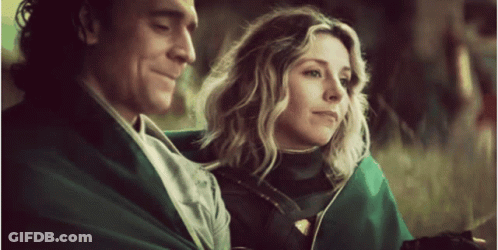 A Man And A Woman Are Sitting Next To Each Other . GIF