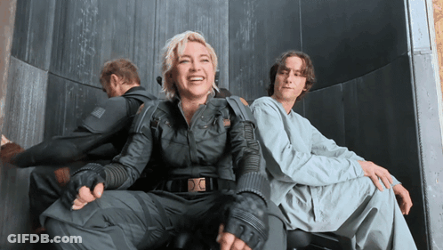 A Man And A Woman Are Sitting Next To Each Other GIF