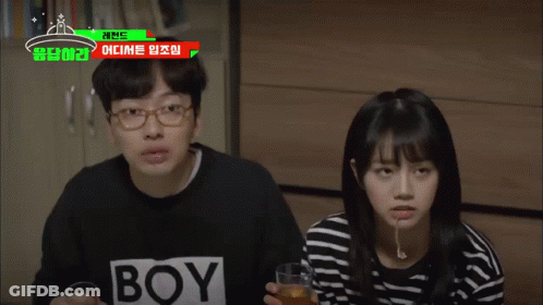 A Man And A Woman Are Sitting Next To Each Other With A Boy Shirt On GIF
