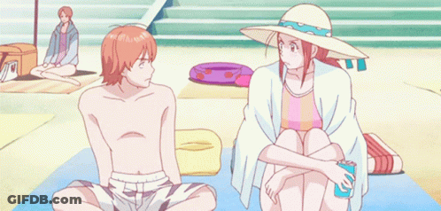 Man And Woman Sitting On Beach Woman Pointing GIF