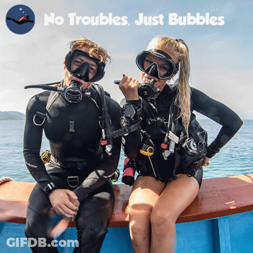 A Man And A Woman Are Sitting On A Boat With The Words " No Troubles Just Bubbles " Behind Them GIF