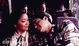 A Man And A Woman Are Sitting On A Bus And Looking At Each Other . GIF