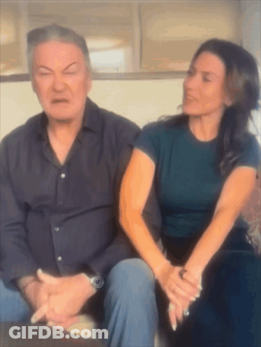 Man And Woman Sitting On Couch Woman Making Face GIF