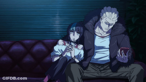 A Man And A Woman Are Sitting On A Couch And The Woman Is Smoking A Cigarette GIF