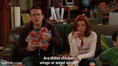 A Man And A Woman Are Sitting On A Couch Eating Chicken Wings And The Woman Asks Are These Chicken Wings GIF