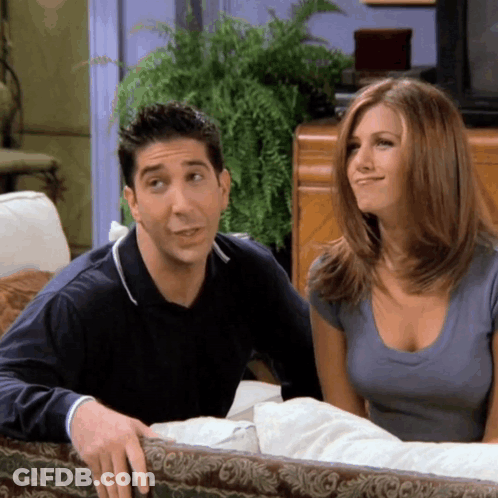 A Man And A Woman Are Sitting On A Couch GIF