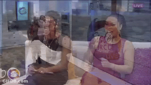 A Man And A Woman Are Sitting On A Couch In Front Of A Live Screen GIF