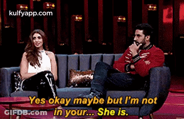 A Man And A Woman Are Sitting On A Couch . GIF
