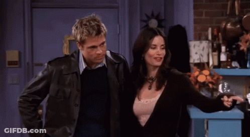 A Man And A Woman Are Sitting On A Couch Talking To Each Other GIF