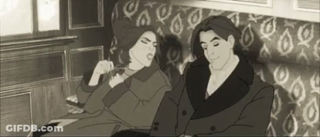 A Man And A Woman Are Sitting On A Couch Together . GIF