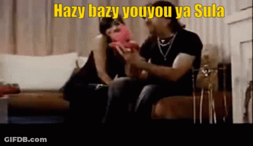 A Man And A Woman Are Sitting On A Couch With Hazy Bazy Youyou Ya Sula Written On The Bottom GIF