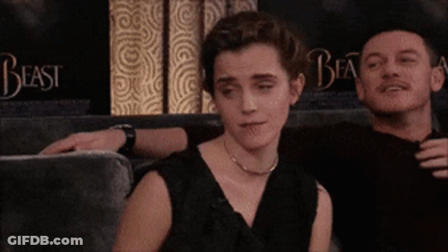 A Man And A Woman Are Sitting On A Couch With The Word Beast Behind Them GIF