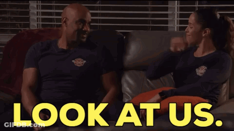 A Man And A Woman Are Sitting On A Couch With The Words " Look At Us " Behind Them GIF