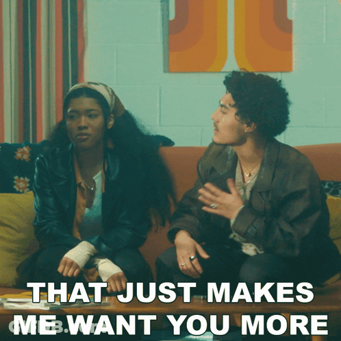 A Man And A Woman Are Sitting On A Couch With The Words That Just Makes Me Want You More GIF