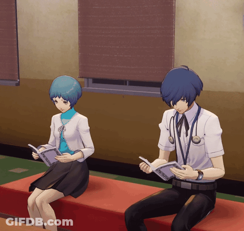 A Man And A Woman Are Sitting On A Red Couch Reading Books GIF