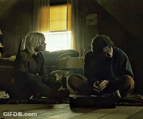 A Man And A Woman Are Sitting On The Floor Talking GIF