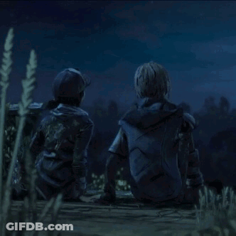 A Man And A Woman Are Sitting On The Ground Looking At The Night Sky . GIF