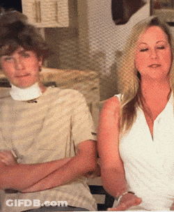 A Man And A Woman Are Sitting With Their Arms Crossed GIF