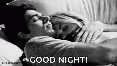 A Man And A Woman Are Sleeping In A Bed And The Man Is Hugging The Woman . GIF