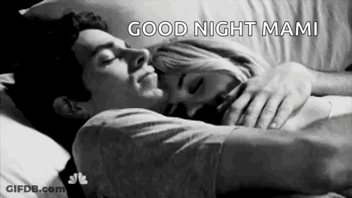 A Man And A Woman Are Sleeping In A Bed Together . GIF