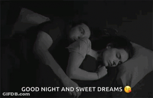 A Man And A Woman Are Sleeping Together In A Bed . GIF