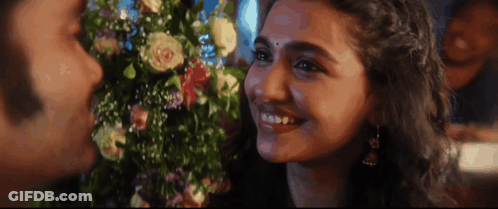 A Man And A Woman Are Smiling And Looking At Each Other GIF