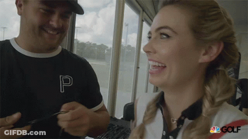 A Man And A Woman Are Smiling And The Woman Is Wearing A Shirt With The Letter P On It GIF