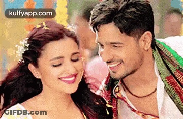 A Man And A Woman Are Smiling For The Camera . GIF