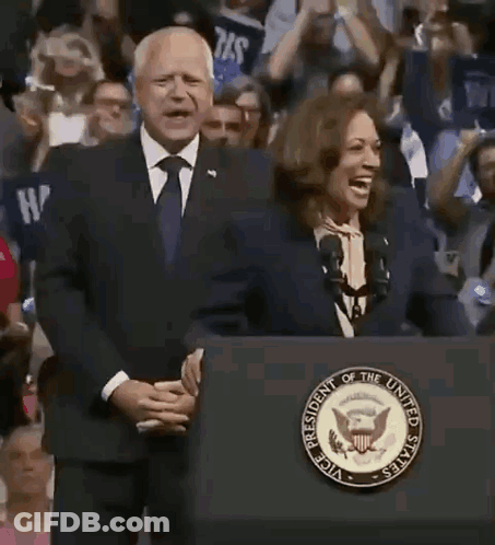 A Man And A Woman Are Standing Behind A Podium That Says President Of The United States On It . GIF
