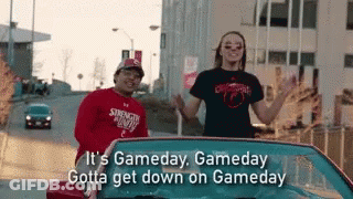 A Man And A Woman Are Standing In A Car With The Words It 'S Gameday , Gameday Gotta Get Down On Gameday GIF