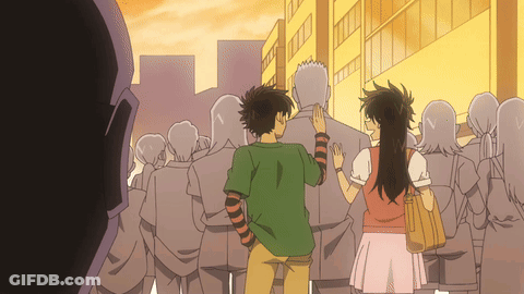 A Man And A Woman Are Standing In A Crowd GIF
