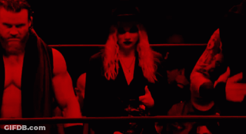 A Man And A Woman Are Standing In A Dark Room With Red Lights GIF